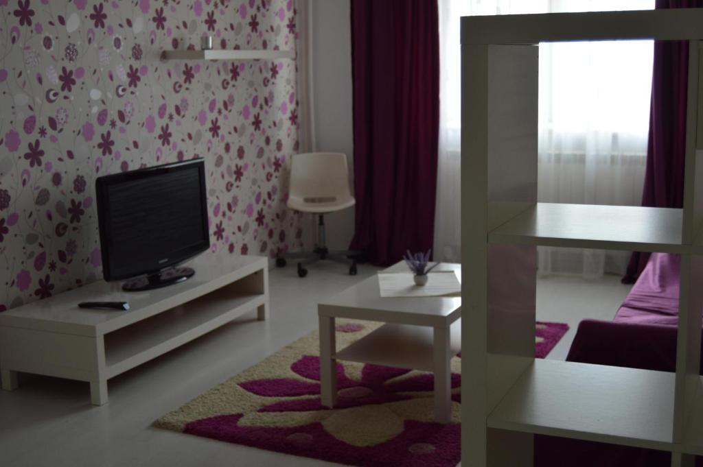 康斯坦察Apartament Faleza Nord的客厅配有电视、沙发和桌子