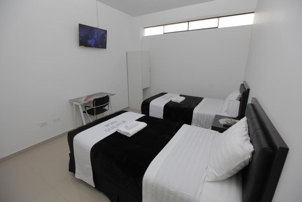 AbancayHotel Murano的白色和黑色客房的两张床