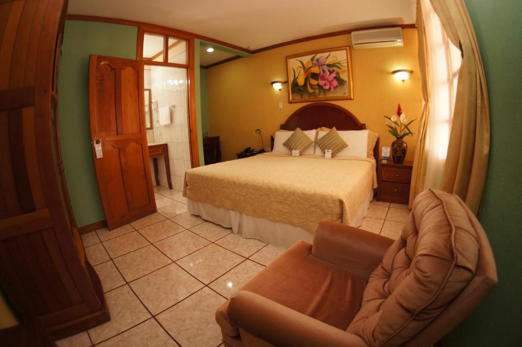 Jinotega咖啡厅酒店的配有一张床和一把椅子的酒店客房