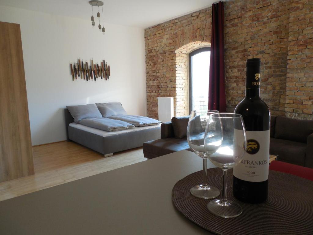 布达佩斯The Old Mill Budapest的桌子上放有一瓶葡萄酒和两杯酒