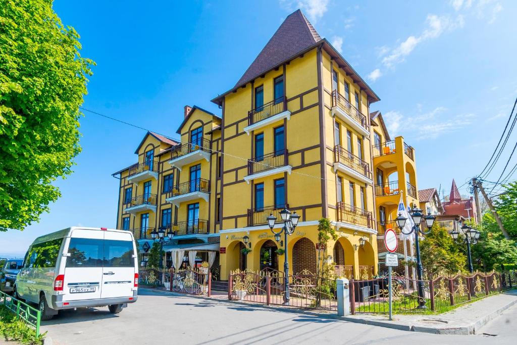 泽列诺格拉茨克伊丽莎公主酒店的停在黄色建筑前面的白色货车