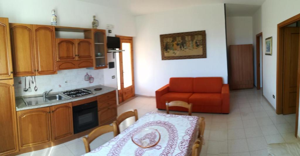 维耶斯泰Villa Lucrezia Trilo的厨房配有桌子和红色沙发