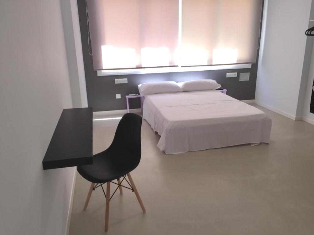 多列毛利诺斯太阳客房宾馆（拉诺加雷拉广场）的卧室配有1张床、1张桌子和1把椅子