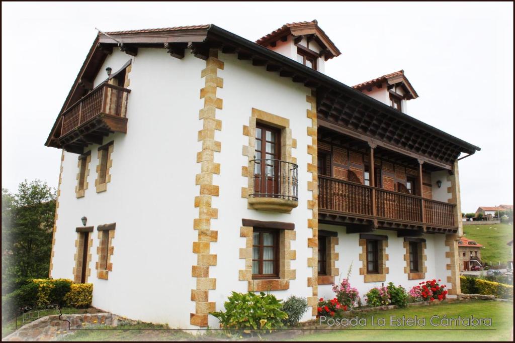 Toñanes拉埃斯特拉坎塔布莱波萨达酒店的白色房子,有 ⁇ 帽屋顶