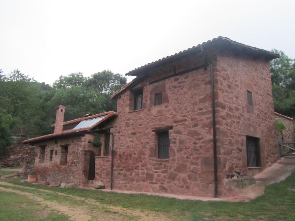 TurzaCasa de Montaña La Solana de Turza的田野上的旧砖砌建筑