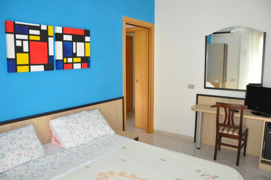 佩斯卡拉欧西住宿加早餐旅馆的一间卧室配有一张床、一张书桌和一幅画