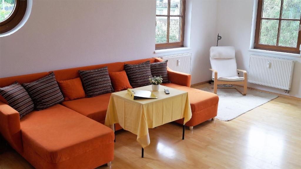 因斯布鲁克Ferienwohnung-Apartment Monika in Innsbruck-Igls的客厅配有橙色沙发和桌子