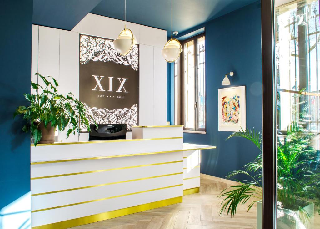 贝济耶Hôtel le XIX的大堂设有蓝色的墙壁和白色的植物台面