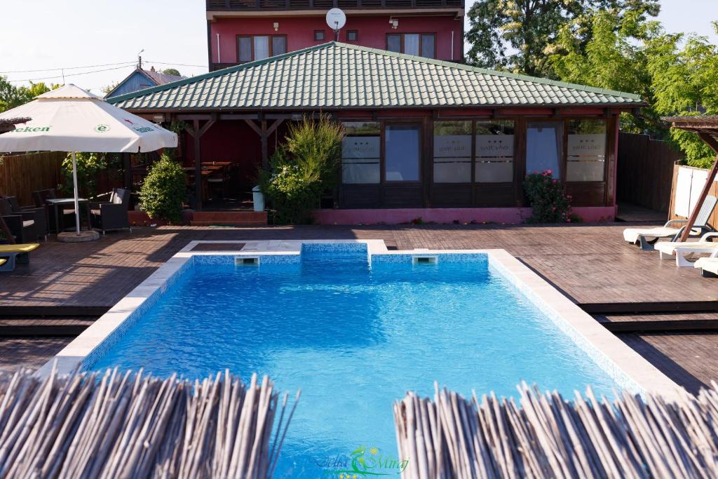 苏利纳戴尔塔麦拉旅馆的一座房子旁带遮阳伞的游泳池