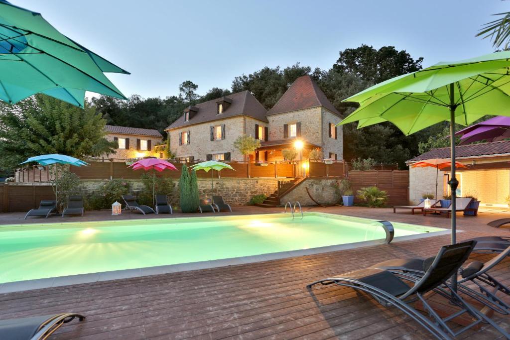 卡尔萨克阿亚克Domaine de Campagnac - Spa & Sauna的一个带椅子和遮阳伞的游泳池