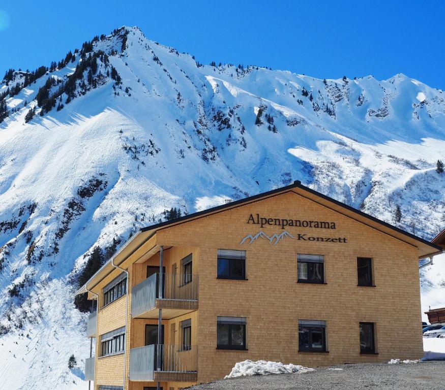 法斯奇纳Alpenpanorama Konzett的雪覆盖的山前的建筑物