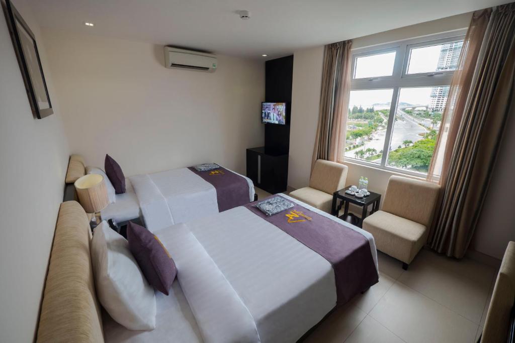 岘港Azumaya Hotel Da Nang的酒店客房设有两张床和窗户。