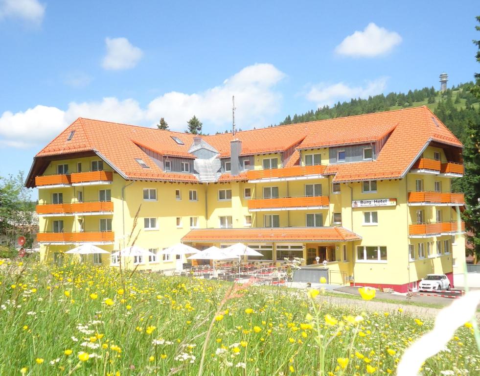 费尔德伯格费尔德山伯格酒店的一座黄色的大建筑,有橙色的屋顶