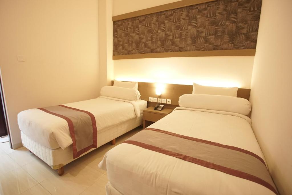 谏义里Viva Hotel Kediri by Azana的一间酒店客房内设有两张床的房间