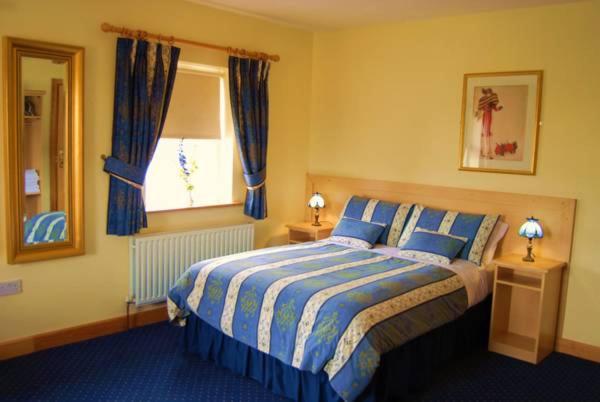RathowenFeerick's Hotel的一间卧室配有床和蓝色窗帘的窗户