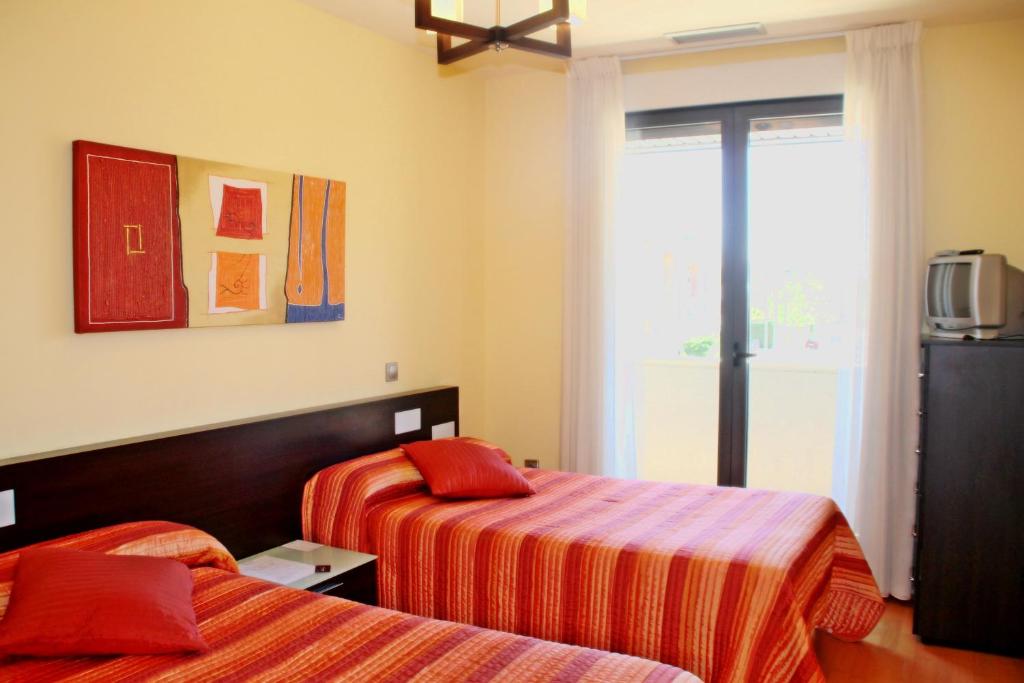 阿罗约德莱恩科缅达里贝拉公寓酒店的酒店客房设有两张床和窗户。