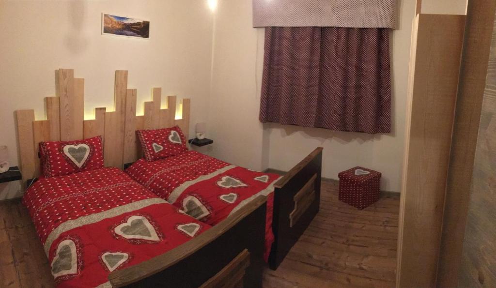 巴切诺Le samantine的一间卧室配有红色床单和红色枕头。