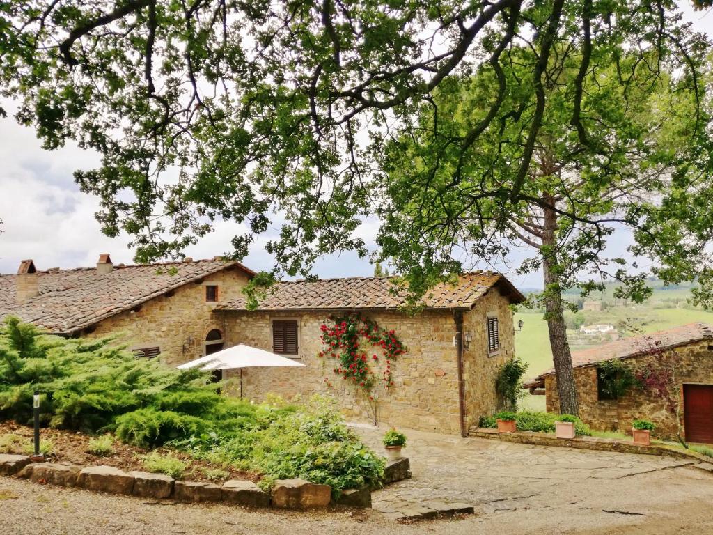 潘札诺Villa Toscana Il Capiteto的前面有棵树的石头房子