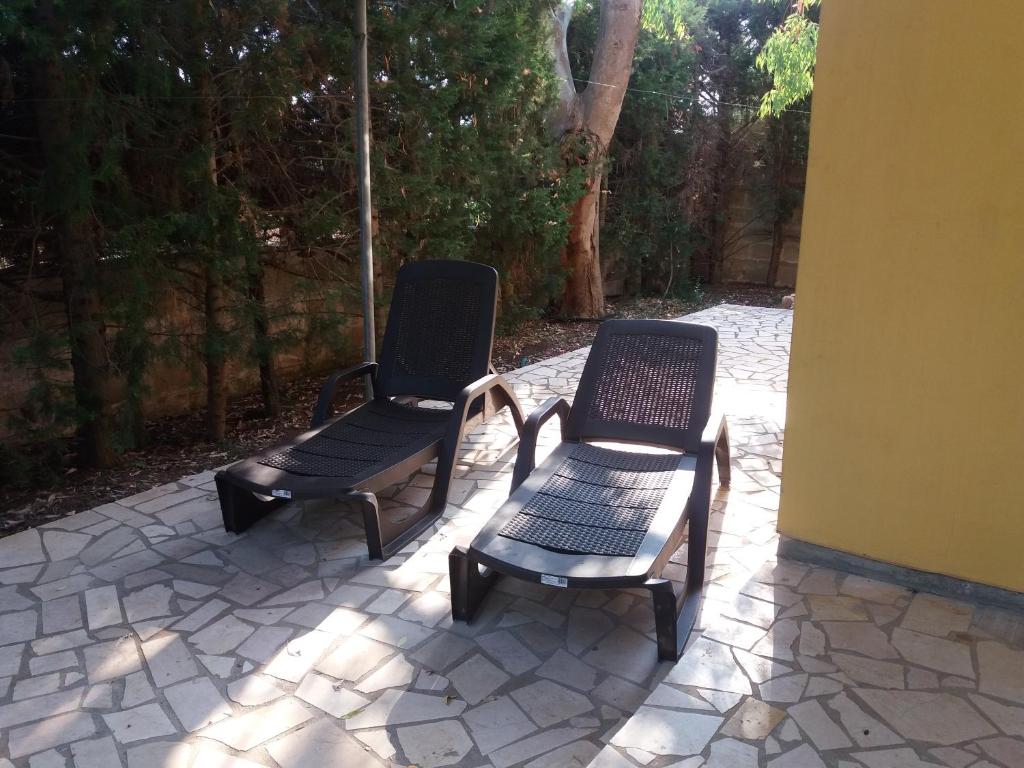 托雷拉皮罗Villa Aloe的庭院设有两把椅子和一张长凳