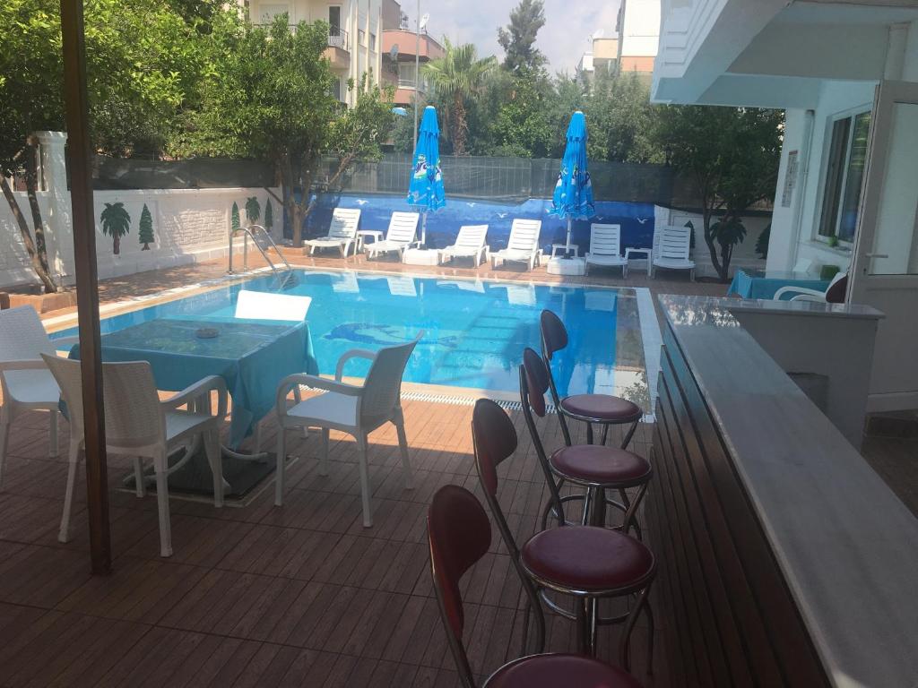 安塔利亚Konyaaltı HOTEL的一个带椅子和桌子的游泳池