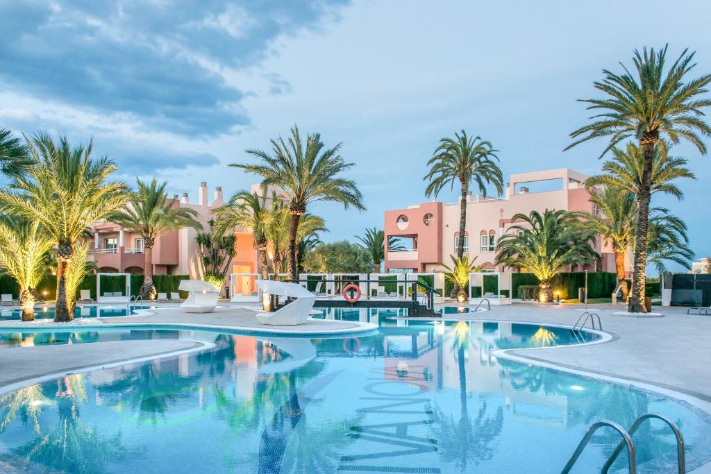 奥利瓦奥利瓦新星海滩高尔夫酒店 的一座棕榈树和建筑的大型游泳池