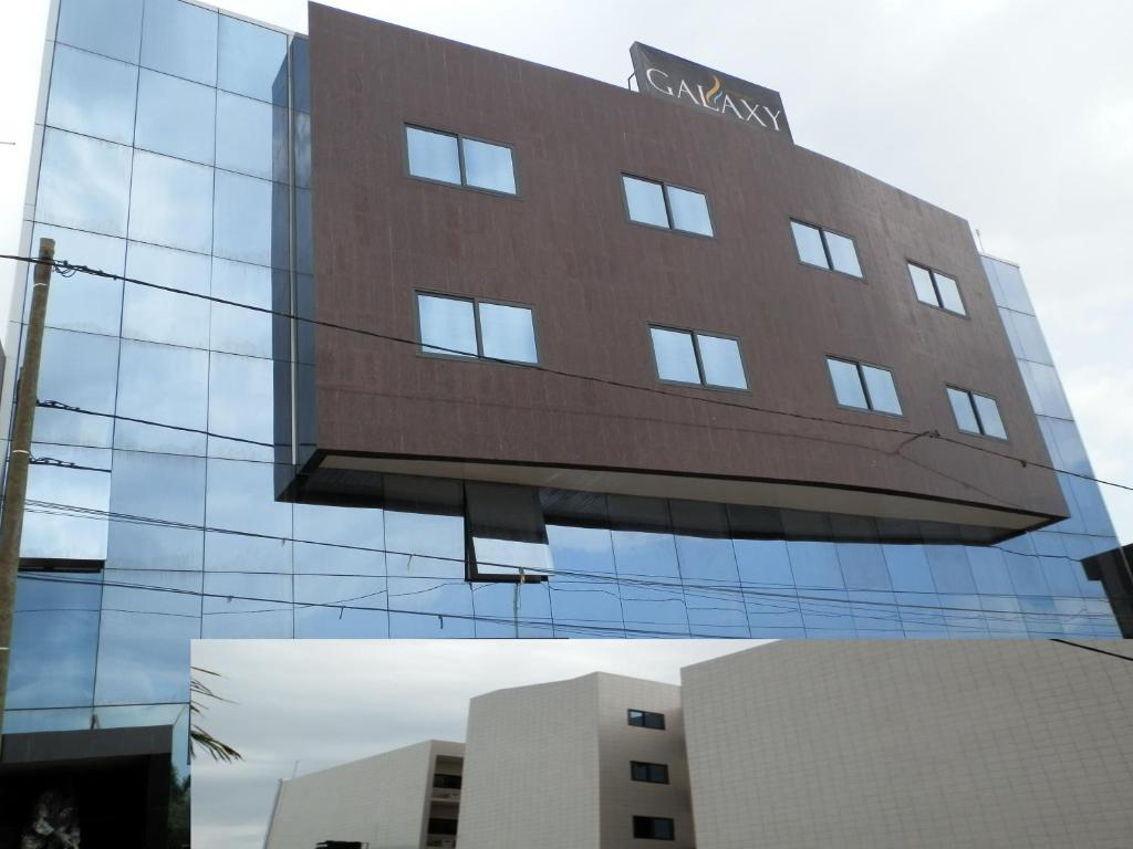 洛美Residence Galaxy Togo的一座高大的玻璃建筑,上面有标志