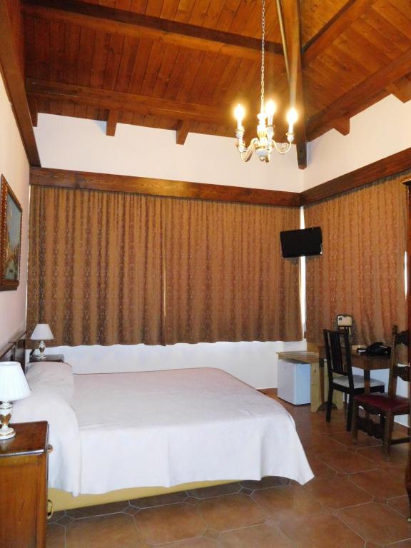 San Bartolomeo in GaldoHotel Michelangelo的一间卧室配有一张床、一张桌子和一台电视