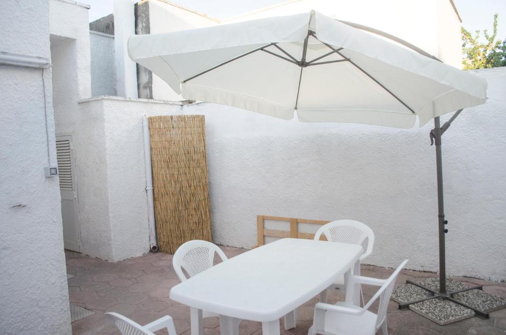 阿韦特拉纳White Salento的白色的桌子和椅子以及雨伞