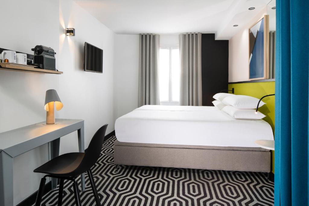 巴黎霹雳姆酒店的配有一张床和一张书桌的酒店客房