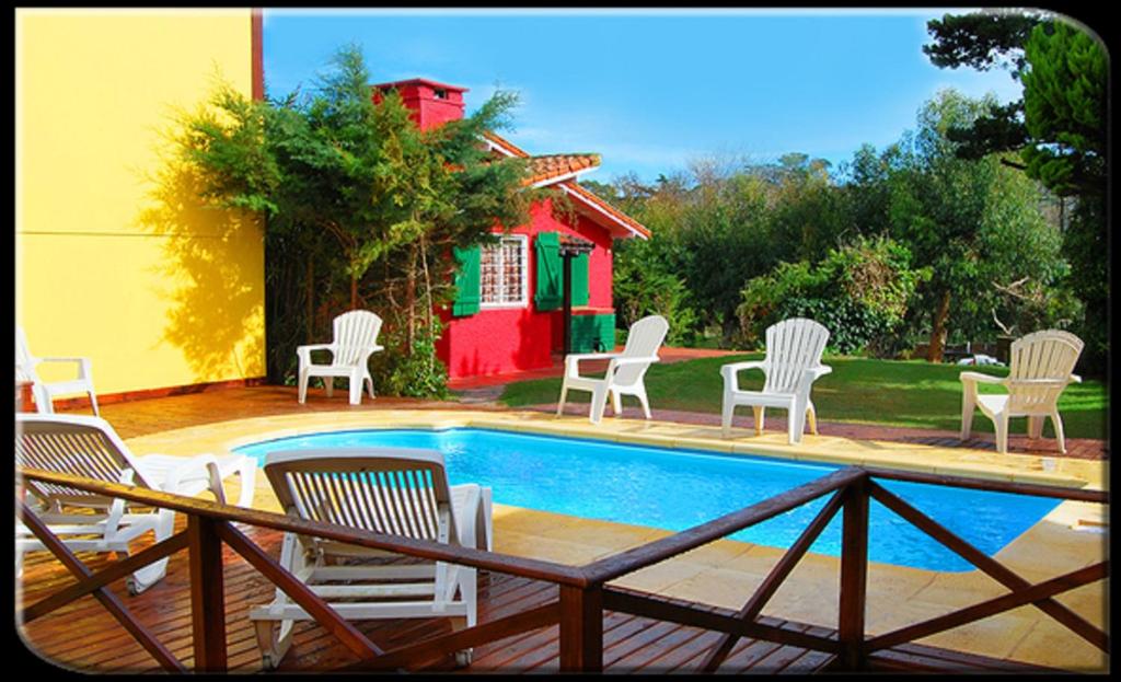 格塞尔镇Villa Olimpia Cabañas的一组椅子坐在游泳池周围