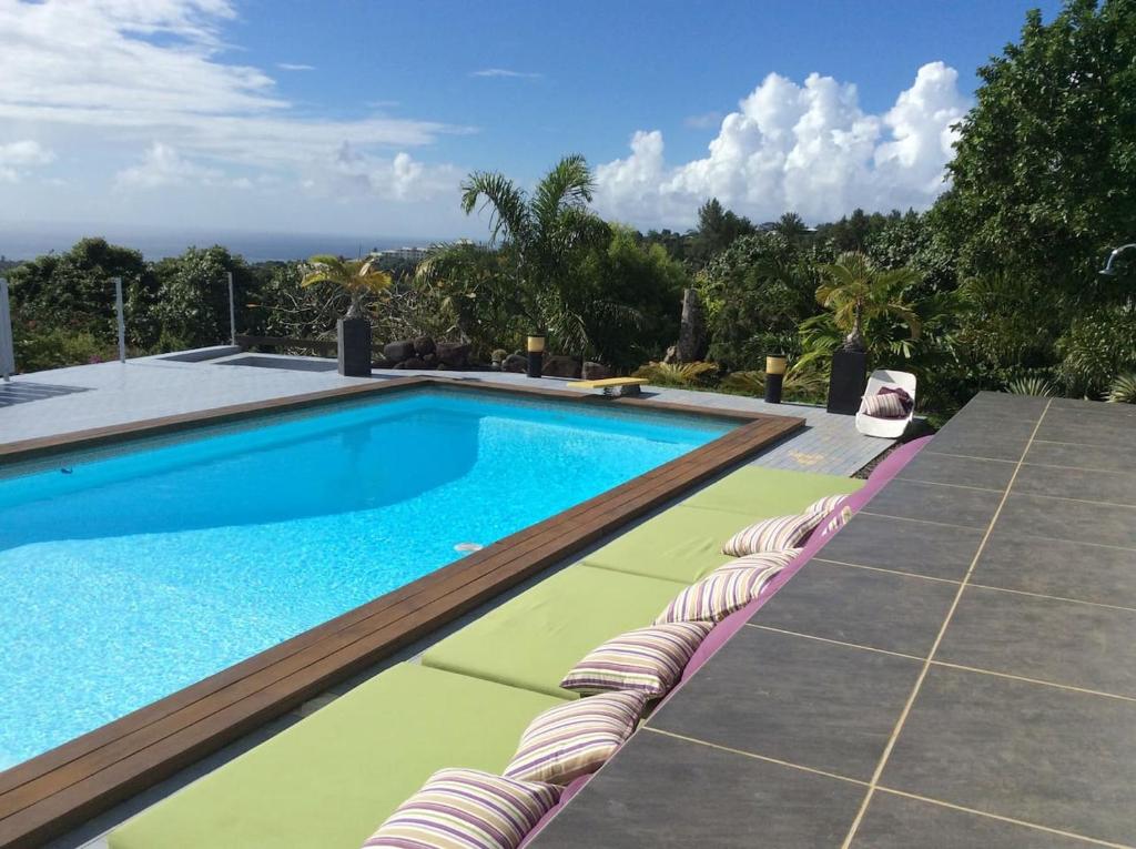 普纳奥亚Bungalow Premium Tahiti的一个带躺椅的游泳池和一个游泳池