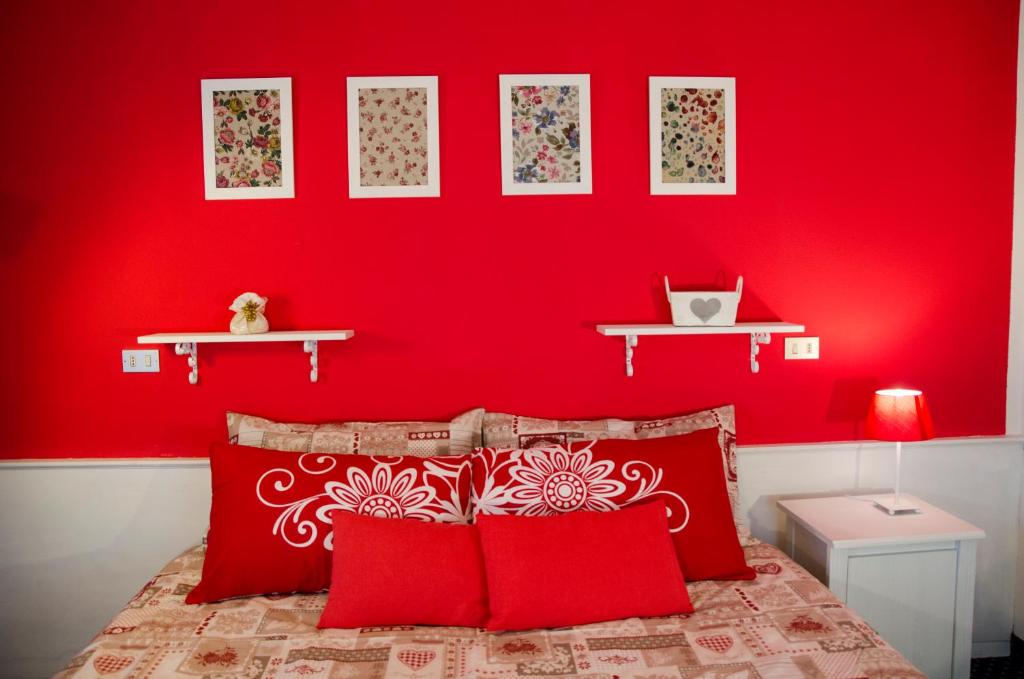瓦尔迪佐多阿尔索尔旅馆的一间卧室设有红色的墙壁和一张带红色枕头的床