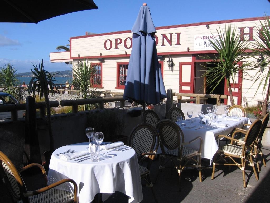 奥波诺尼欧普诺尼酒店的两张桌子,上面有蓝伞和椅子