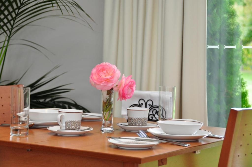 奥兰治Clifton Gardens Bed & Breakfast - Orange的一张带板子的木桌和一个花瓶