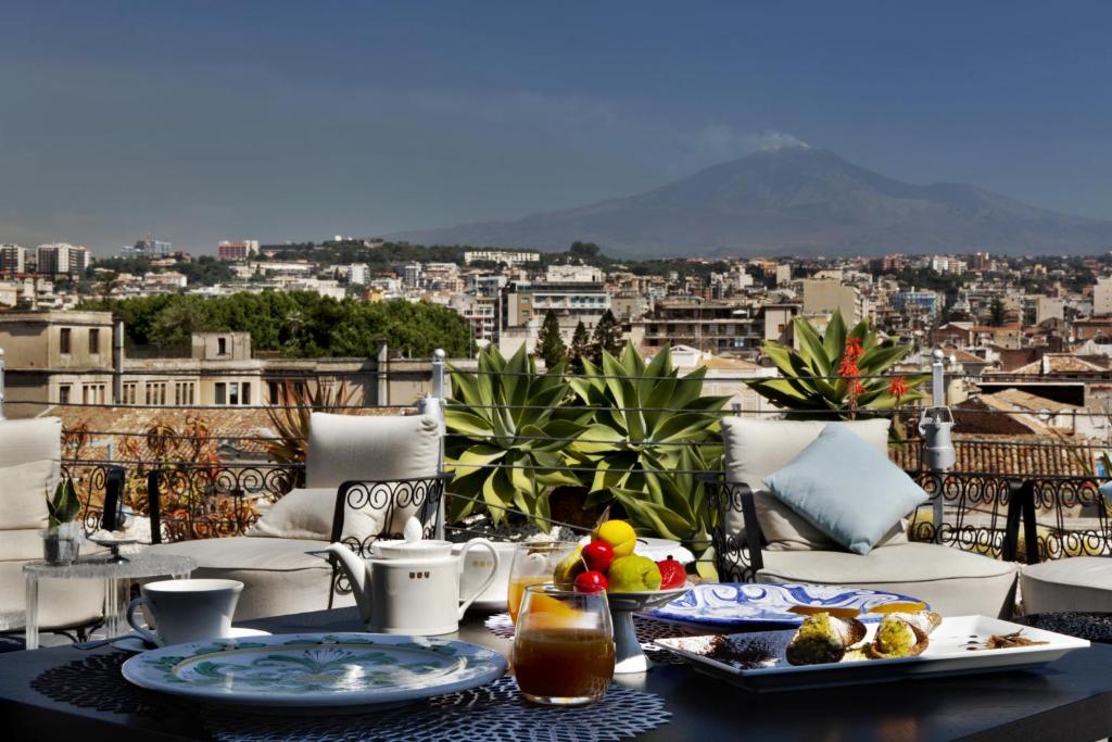 卡塔尼亚Palace Catania | UNA Esperienze的一张桌子,上面放着食物,享有城市美景