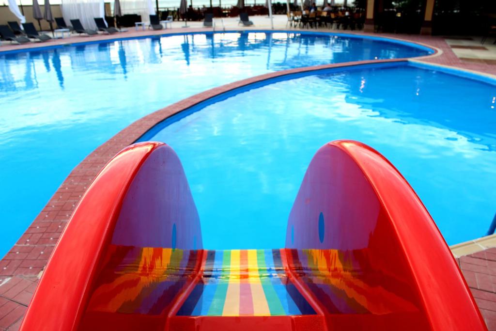 阿克套Dostar Hotel的游泳池,在水中设有多彩的长凳