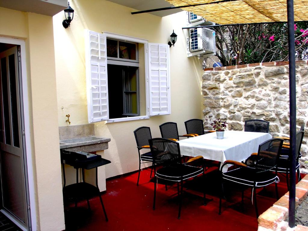 拉布Holiday Home Lija Center的一个带石墙的庭院内的桌椅