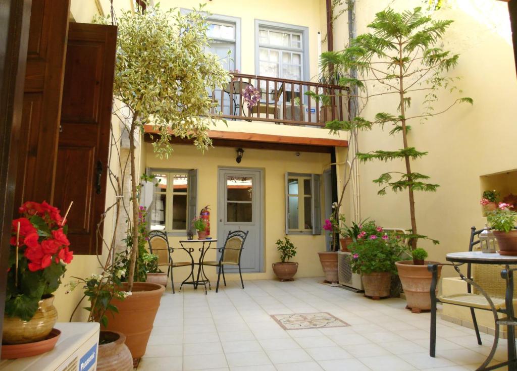 干尼亚麦当娜一室公寓酒店的一个带桌椅和盆栽的庭院