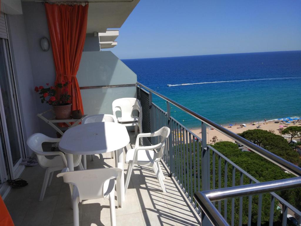 布拉内斯Atico Condal的一个带桌椅和海滩的阳台