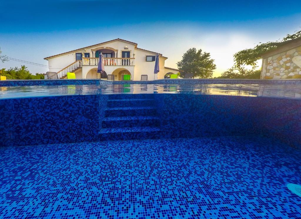 沃德年Apartments Chipo的蓝色的游泳池,后面有房子