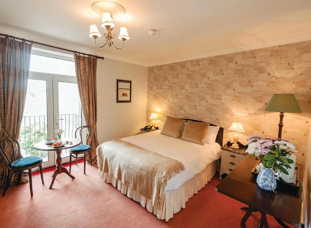 克洛纳基尔蒂O'Donovan's Hotel的配有一张床、一张桌子和一张桌子的酒店客房