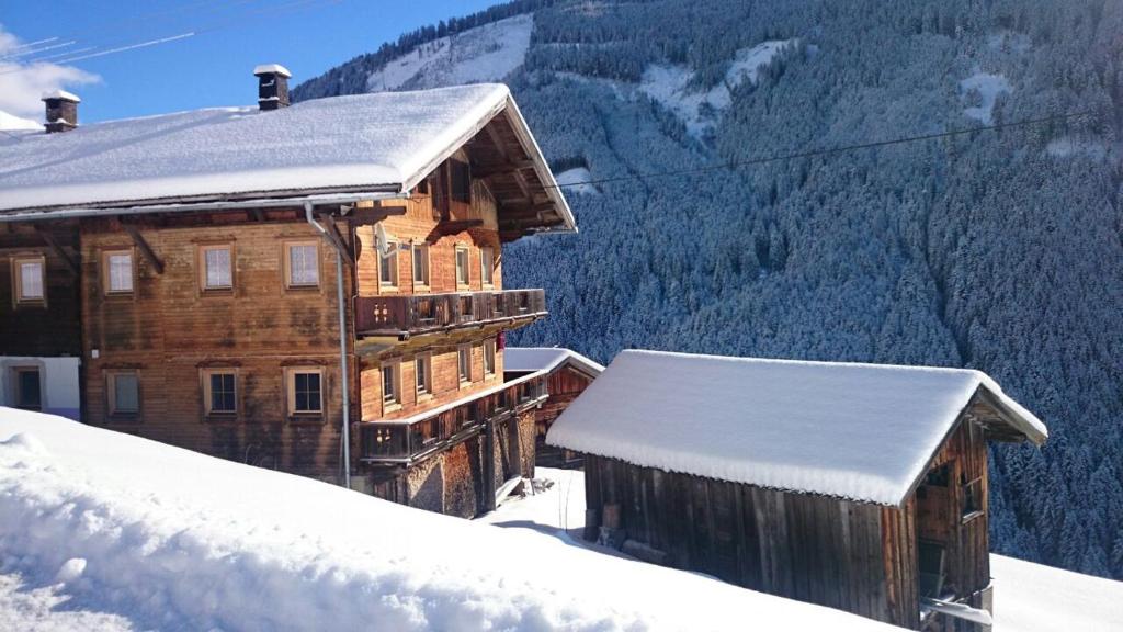 施图默尔贝格Steinwandhütte的一座覆盖着雪的木制建筑,背景是群山