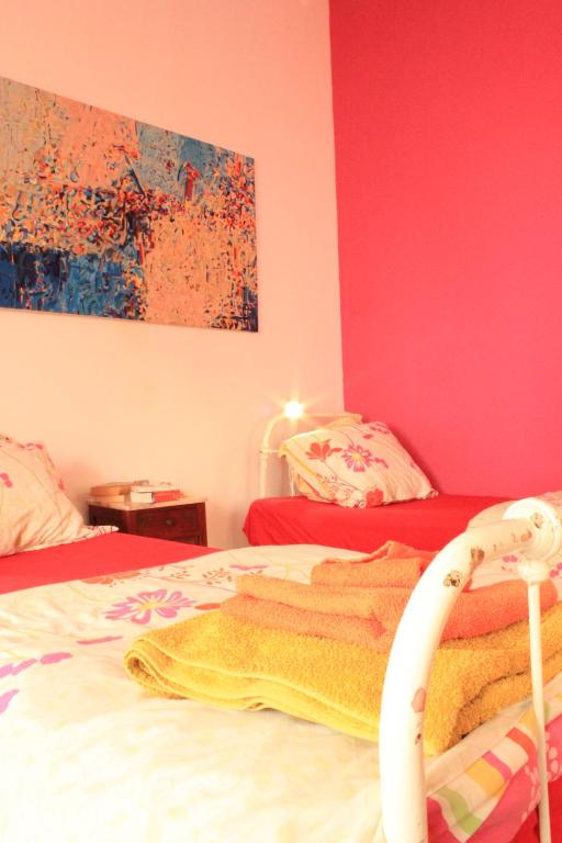 Trafaria福戈度假屋的一间卧室配有两张粉红色墙壁的床