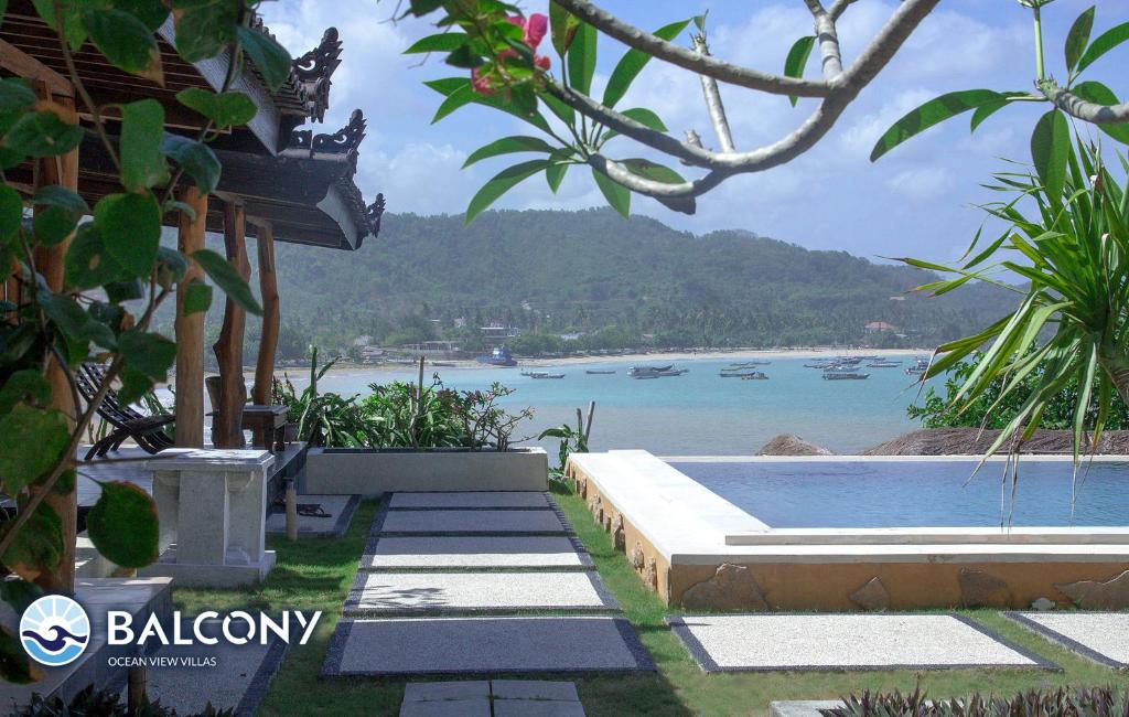 龙目岛库塔海景阳台别墅酒店的享有水景和房屋景色的度假胜地