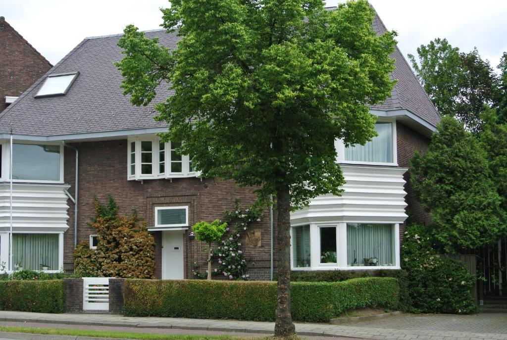 马斯特里赫特Aldenhof Appartementen的前面有一棵树的房子