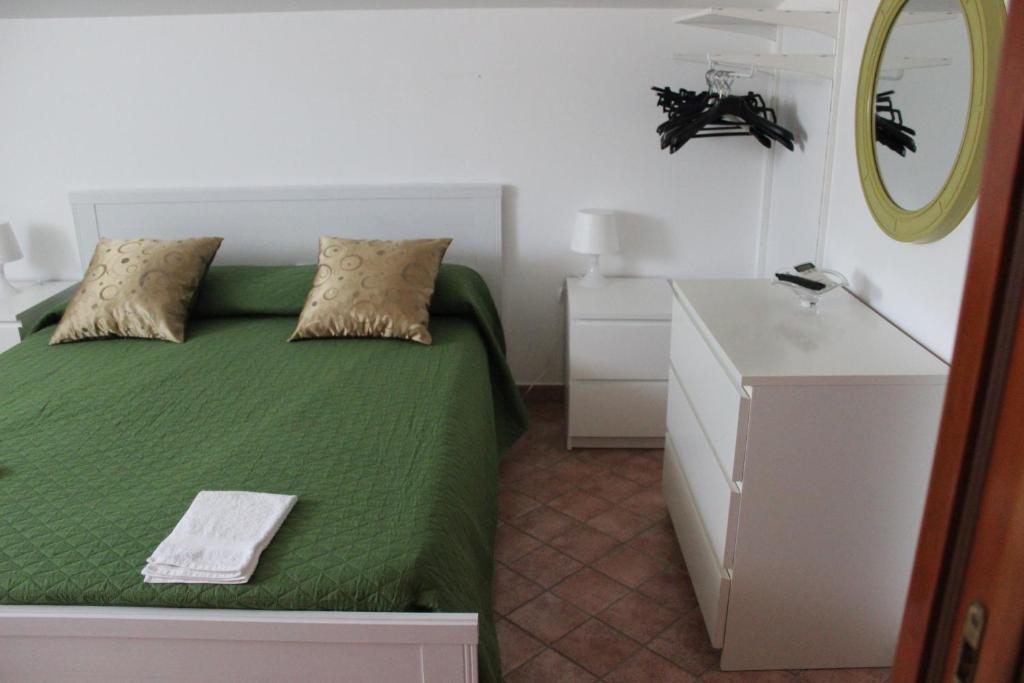 马泰拉皮佐卡尼奇奥住宿加早餐旅馆的一间卧室配有绿色的床和镜子