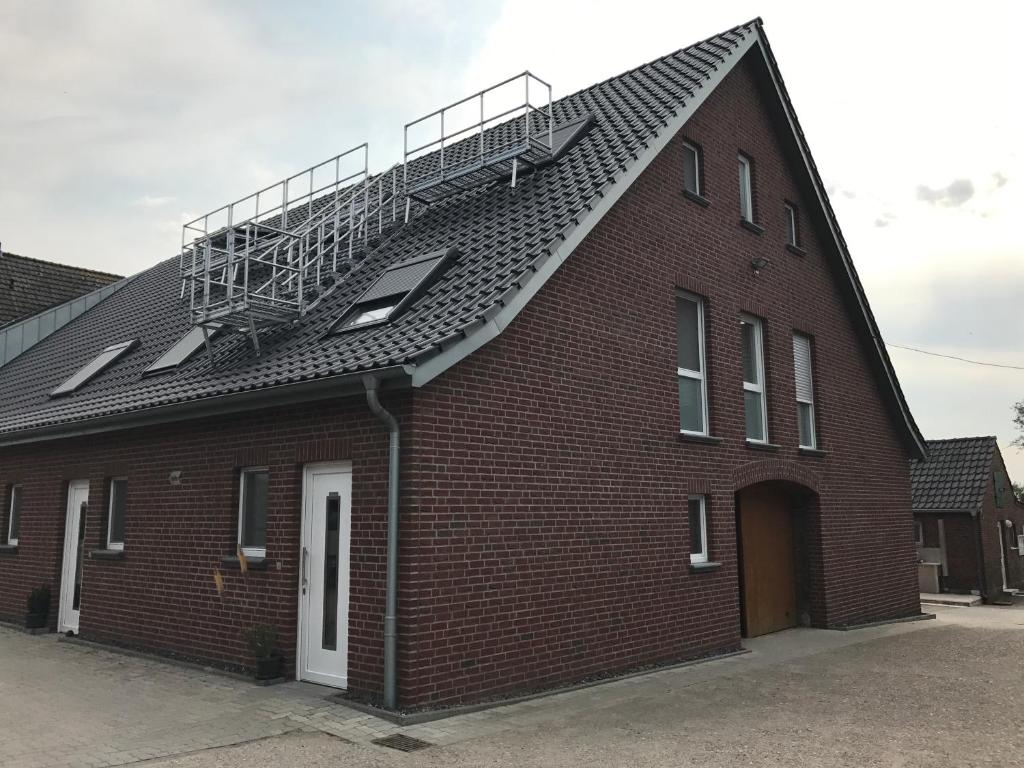 MehrhoogFerienwohnung Hagener Meer的一座红砖建筑,屋顶上设有楼梯