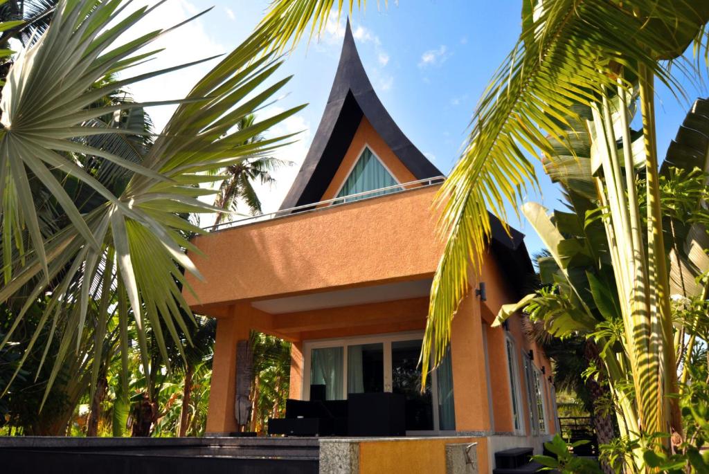 象岛白龙海景别墅的一座有尖顶和棕榈树的房子