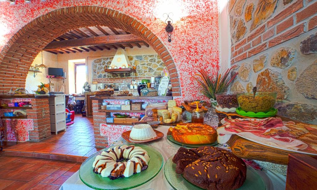 森普罗尼亚诺橄榄谷农家乐的厨房配有带不同类型蛋糕的桌子