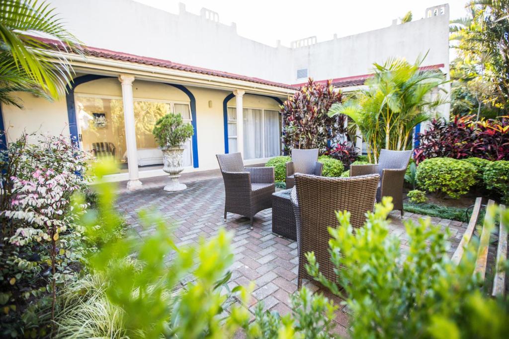 东伦敦Santorini Guesthouse的庭院里种有椅子和植物的庭院